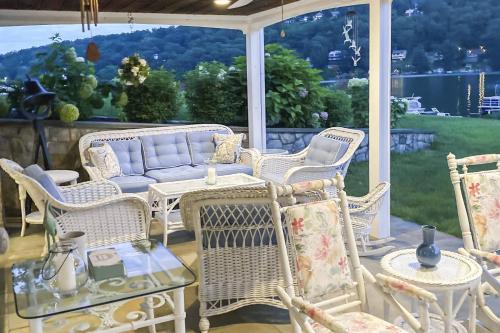 a porch with wicker chairs and a table and a couch at Candlewood Lake House in Danbury