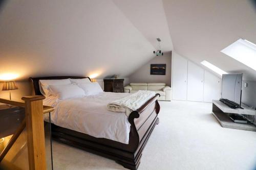 a bedroom with a large bed and a television at Woodhead view in Kirkintilloch