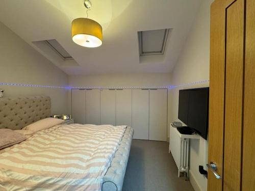 a bedroom with a bed and a flat screen tv at NORTHBRIDGE in Tonbridge