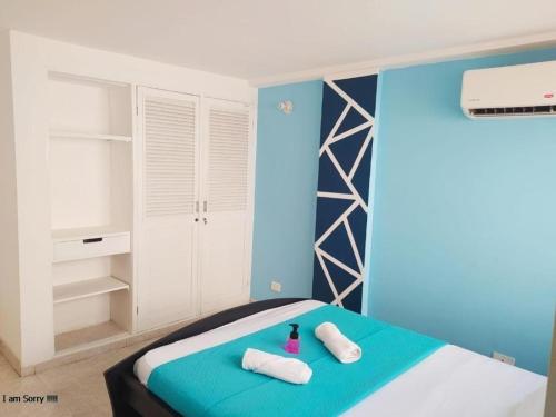 a bedroom with a bed with two towels on it at APT en EDF Frente a la playa y cercano centro Histórico 1-2 in Cartagena de Indias