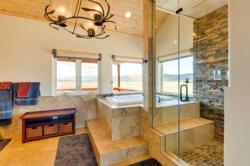 une grande salle de bain avec une baignoire et un lustre dans l'établissement Hot Tub and Fire Pit Idyllic Getaway in Angel Fire!, à Angel Fire