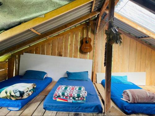 two beds in a room with a guitar at Cabaña y temazcal Mastai in Jardin