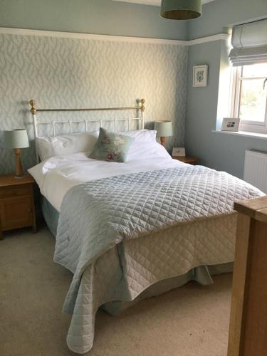 a bedroom with a large bed with white sheets and a window at A place to stay in Stoke Gifford - Parkway train station 5 min walk in Bristol