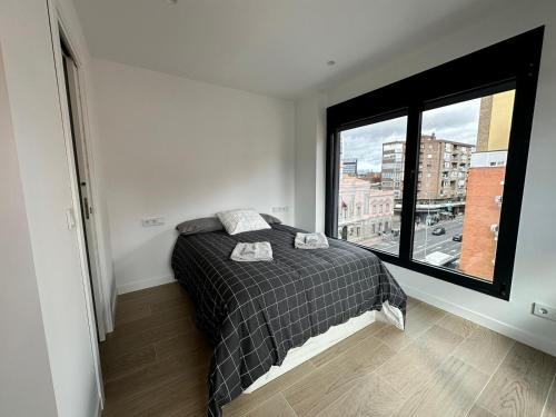 a bedroom with a bed and a large window at CASTILLA LUXURY B Apartments in Madrid