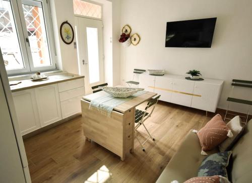 sala de estar con sofá, mesa y TV en [Double Free Parking] Anna Verrà Cottage, en Marano di Napoli