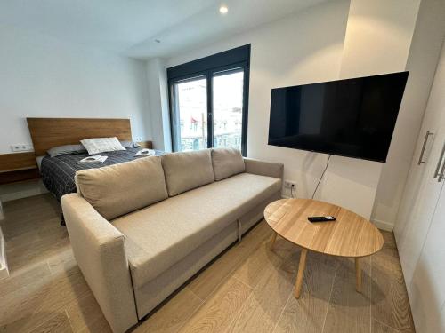 sala de estar con sofá y cama en Castilla Luxury 2B Apartment, en Madrid