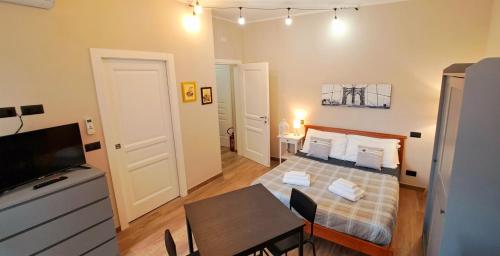 a small room with a bed and a dining table at MarTina's Home GRIS in Alba