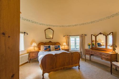 a bedroom with a large bed and two mirrors at The Oast by Bloom Stays in Newenden
