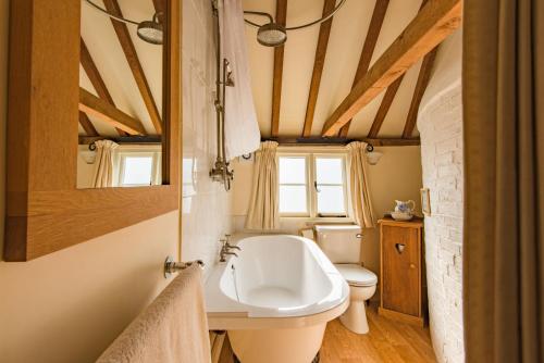 La salle de bains est pourvue d'un lavabo blanc et de toilettes. dans l'établissement The Oast by Bloom Stays, à Newenden