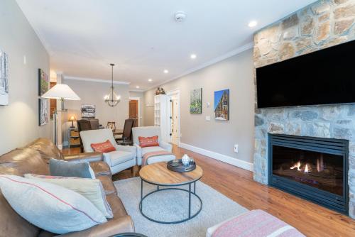 Una sala de estar con chimenea y TV de pantalla plana. en River Club 104 by Alpine Lodging Telluride, en Telluride