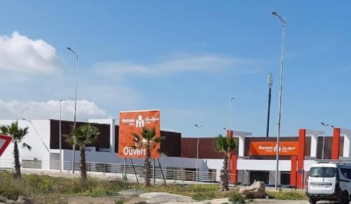 a truck parked in front of a building with palm trees at Apparemment de luxe Bouznika in Bouznika
