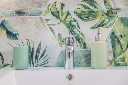 Les Rosiers - Maison avec JACUZZI في بريف لا غايلارد: زجاجتان من الصابون موضوعتان على حوض الحمام