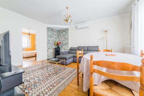ein Wohnzimmer mit einem Bett und einem Sofa in der Unterkunft Les Rosiers - Maison avec JACUZZI in Brive-la-Gaillarde