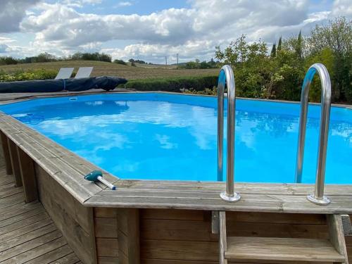 - une piscine avec 2 bars en métal sur une terrasse en bois dans l'établissement Le Petit Coin with pool, near Aubeterre sur Dronne, à Saint-Romain