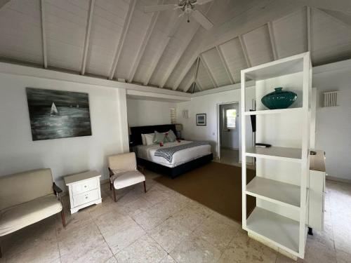 a bedroom with a bed and a chair in a room at Bequia Plantation Hotel in Bequia