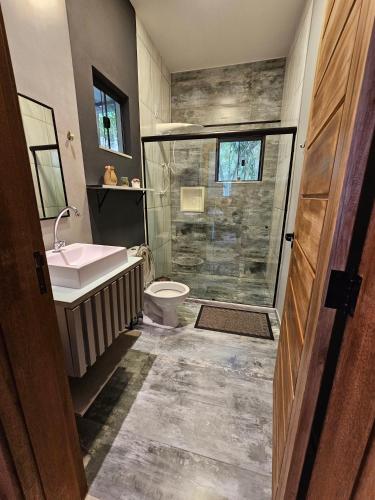 a bathroom with a shower and a sink and a toilet at Pousada Quinta das Nascentes in Petrópolis