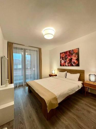 a bedroom with a large bed and a large window at Plovdiv: 1-bedroom apartment with free parking in Sofia