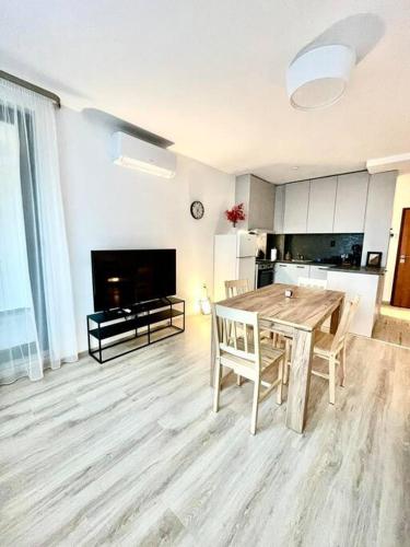 a living room with a wooden table and a kitchen at Plovdiv: 1-bedroom apartment with free parking in Sofia