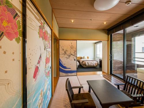 una habitación con mesa y sillas y un dormitorio en LiVEMAX RESORT Kaga Yamashiro en Kaga