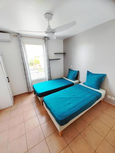 1 dormitorio con 2 camas y ventana en les Aliceas appartement cosy, en Baie-Mahault