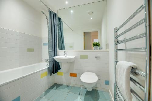 a bathroom with a sink and a toilet and a bath tub at All Saints Apartments 705 by Week2Week in Newcastle upon Tyne