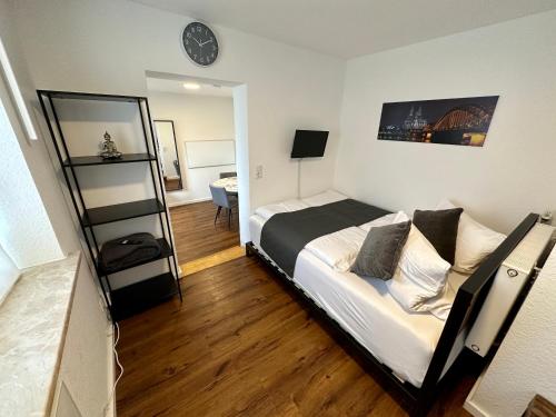 um quarto com uma cama e um relógio na parede em Modernes Apartement am Rhein in ruhiger Lage em Colônia