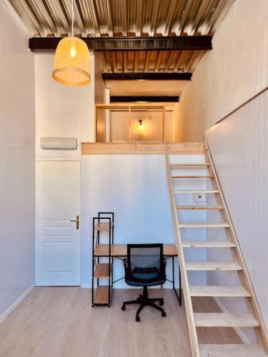 Cette chambre est dotée d'un escalier et d'un bureau avec une chaise. dans l'établissement Loft de 150m2 avec terrasse, à Marseille