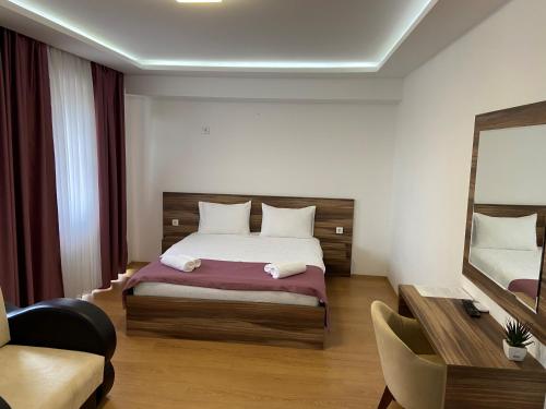 una camera con un grande letto e uno specchio di Prenoćište SRBIJA a Surdulica