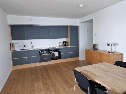 a living room with a table and a kitchen at Tranquil apartment with panorama view over ocean above 20th floor in Aarhus