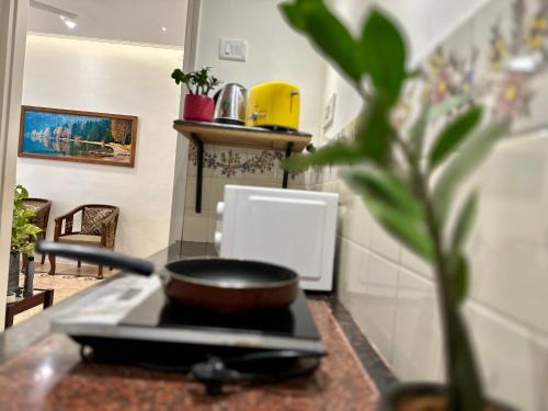 a kitchen with a stove with a pan on it at Nestwood - By The Beach Goa in Benaulim