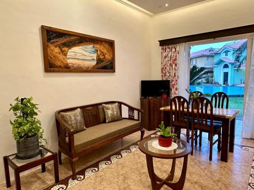 a living room with a couch and a table at Nestwood - By The Beach Goa in Benaulim