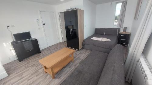 uma sala de estar com um sofá e uma televisão em Spacious Studio Maidstone - Redecorated Oct 2023 em Maidstone
