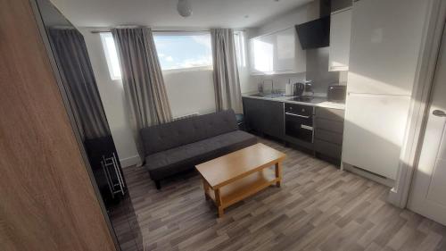 uma pequena sala de estar com um sofá e uma mesa em Spacious Studio Maidstone - Redecorated Oct 2023 em Maidstone