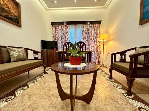 a living room with a table and a couch at Nestwood - By The Beach Goa in Benaulim
