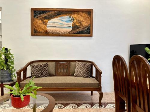 a couch in a living room with a picture on the wall at Nestwood - By The Beach Goa in Benaulim