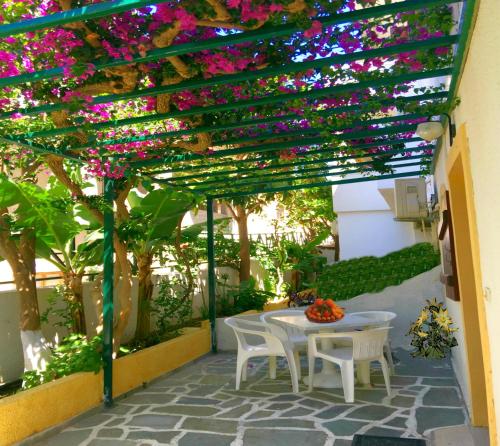 a patio with a table and chairs under a pergola at Kastro Studios Apartments in Myrtos