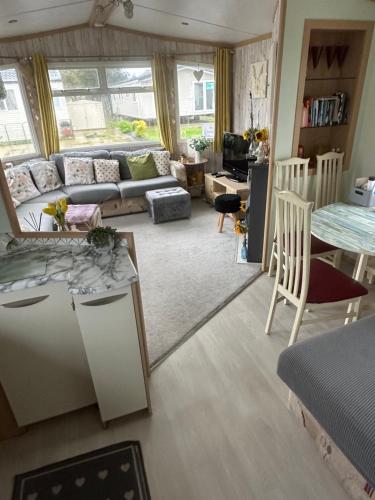 a living room with a couch and a table at Robin Hood Rhyl caravan oaklands in Rhyl
