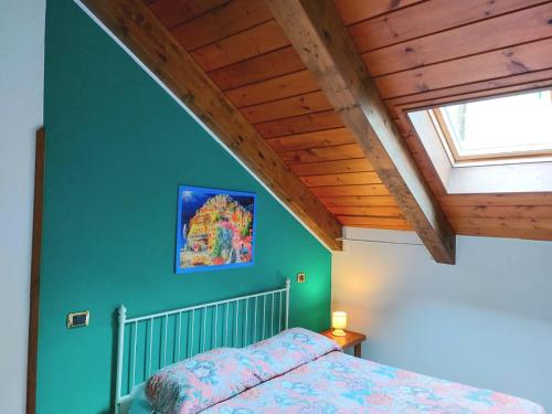 1 dormitorio con 1 cama con pared verde en La Locanda del Pettirosso en Agerola