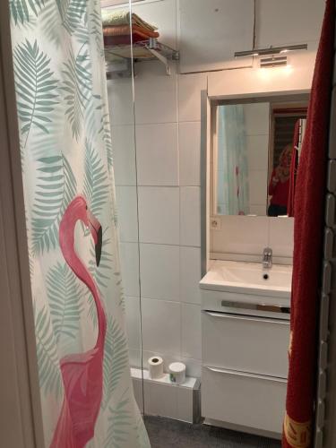 a bathroom with a pink flamingo on the shower curtain at La Coccinelle in Nîmes