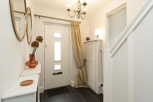 a hallway with a white door and a mirror at Stratford House in Leicester