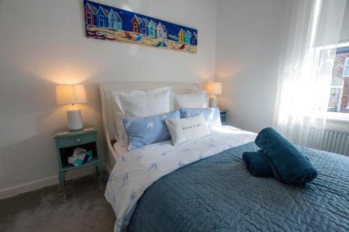 um quarto com uma cama grande e almofadas azuis em Avocet House Hunstanton 250m from the sea em Hunstanton