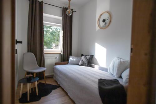 um quarto com uma cama, uma cadeira e uma janela em Apartman Matea em Slavonski Brod