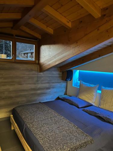 - un lit dans une chambre avec une tête de lit bleue dans l'établissement Hotel Veduta dell'Adamello, à Temù