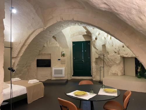 une chambre avec une table et des chaises dans un bâtiment en pierre dans l'établissement Marsili Suite, à Matera