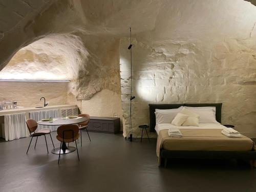 a bedroom with a bed and a table and chairs at Marsili Suite in Matera