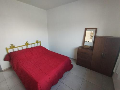 a bedroom with a red bed and a mirror at Kitnet 4 in Cachoeira do Sul