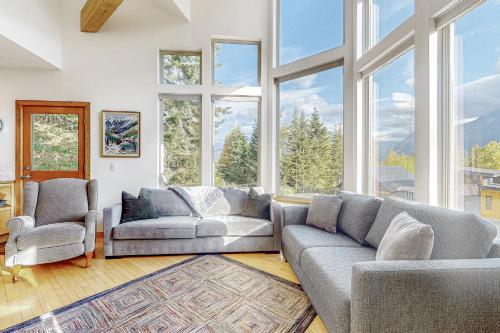 a living room with two couches and large windows at Hyak House in Snoqualmie Pass