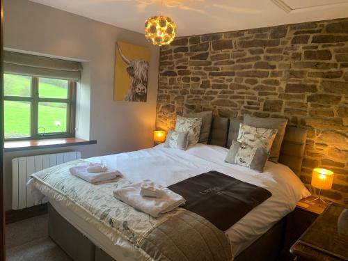 een slaapkamer met een groot bed en handdoeken bij Cuthbert Hill Farm in Preston