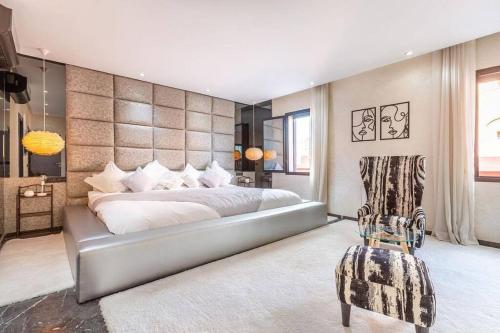 1 dormitorio con 1 cama grande y 1 silla en Splendide Villa Lilya, en Marrakech