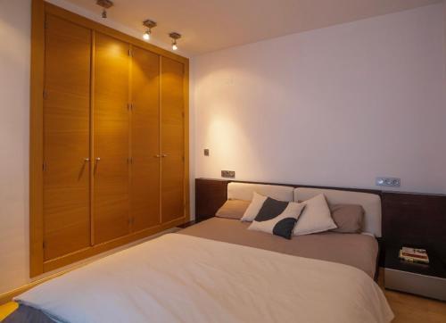 1 dormitorio con 1 cama grande y armario de madera en Alhamar Granada centro, en Granada